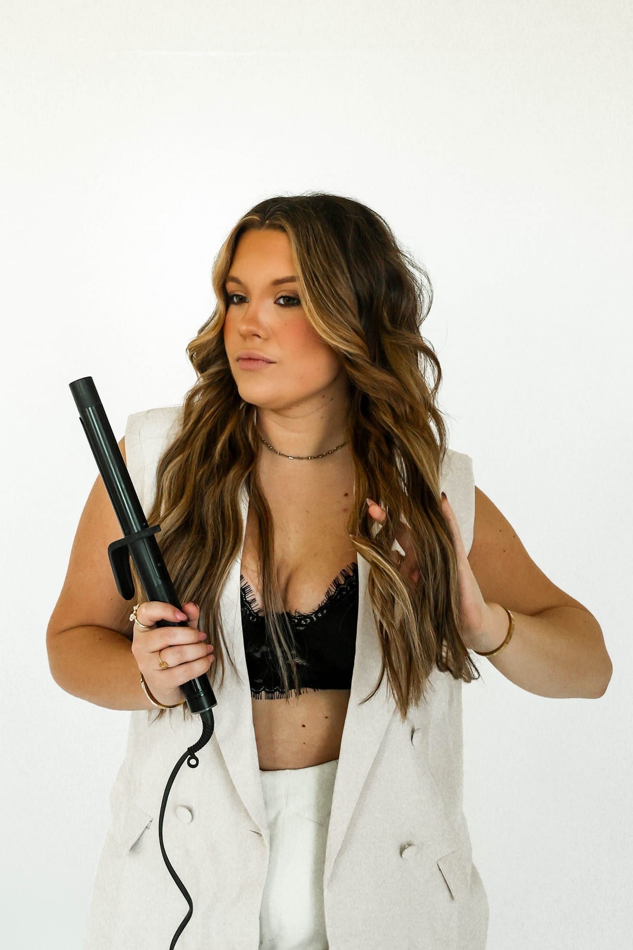 Madi Atkisson holding a curling iron, beachy waves on display