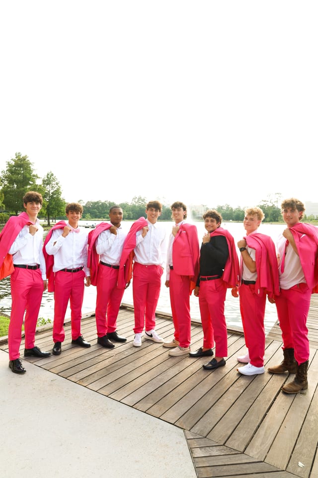 Group of seniors in hot pink suits on a dock