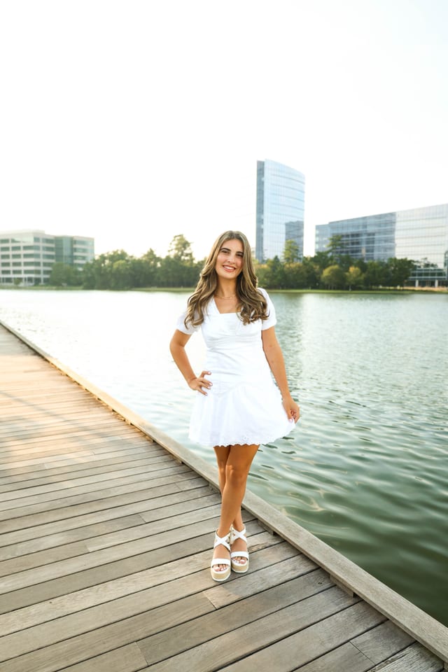Senior in a white dress on a wooden dock