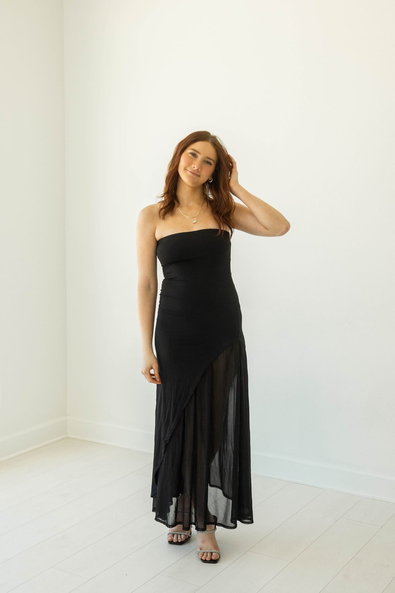 Senior in long black sheer dress in a bright white studio