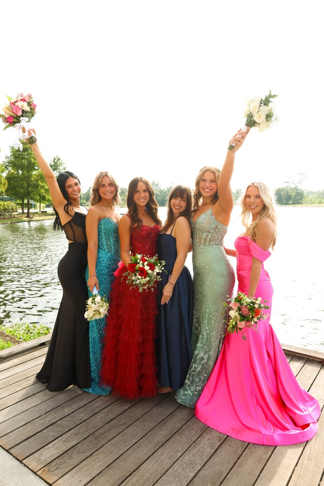 Group of friends in formal gowns on a wooden dock