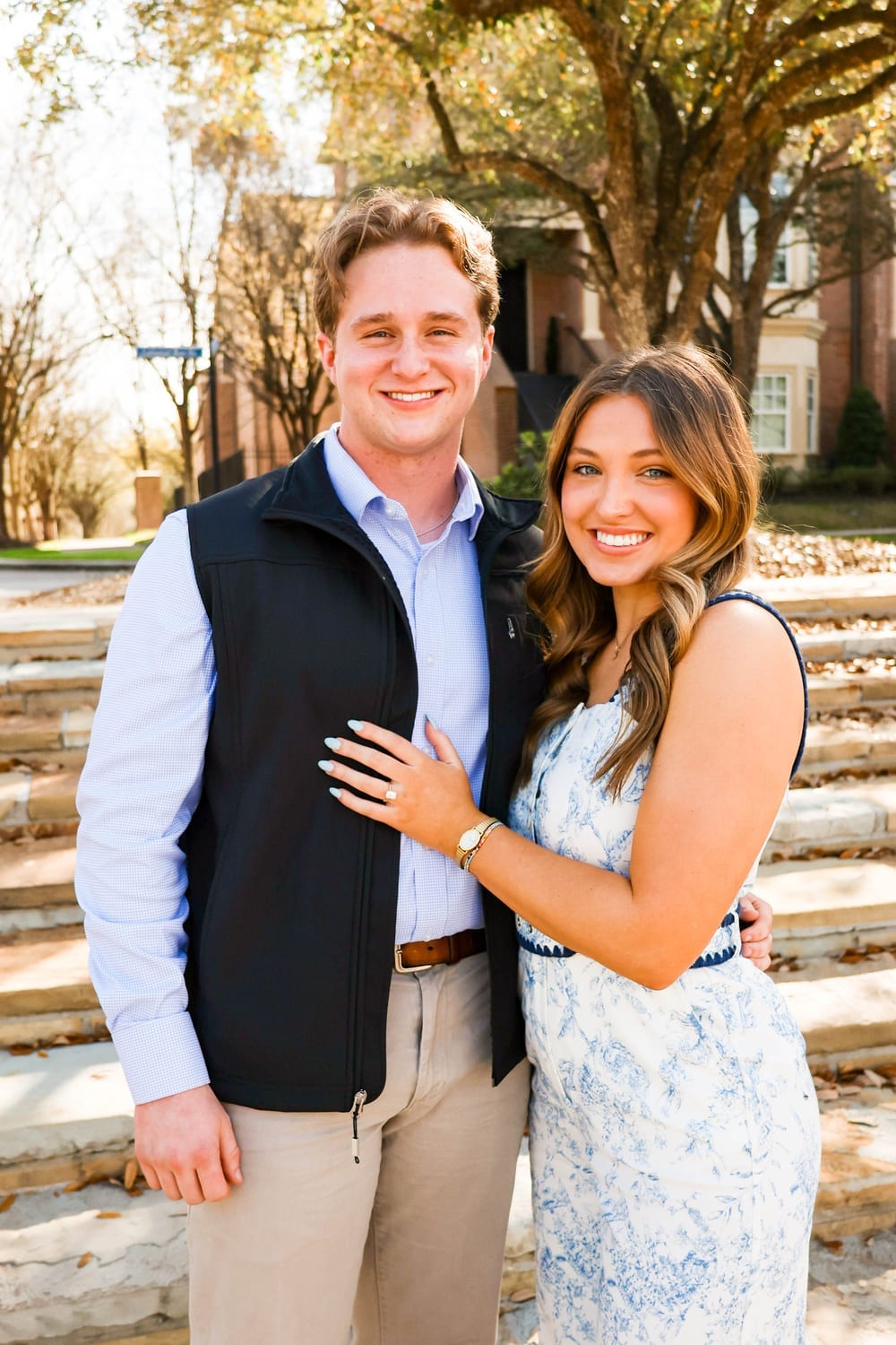 Engaged couple on stairs, ring on display