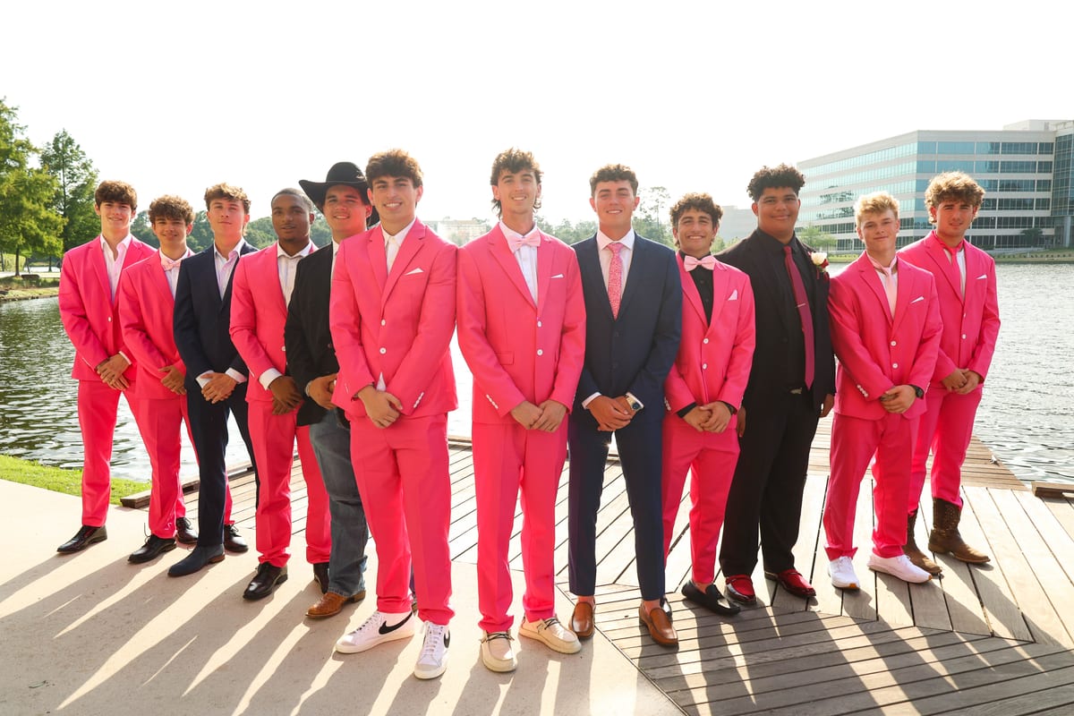 Group of senior guys in pink suits at a waterfront