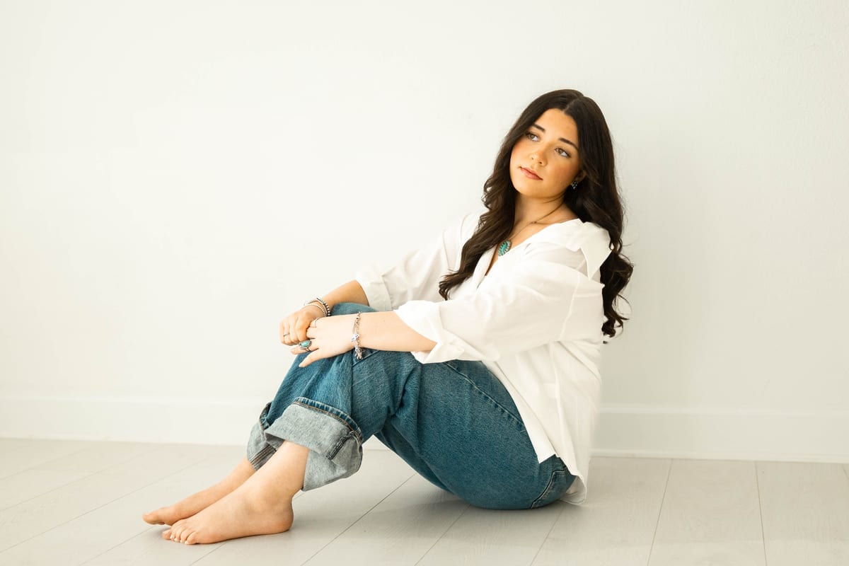 Editorial studio portrait, barefoot on white floor